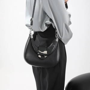 Elegant black hobo bag with silver bow clasp and adjustable strap for shoulder or crossbody use