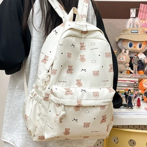 Detail view of a Japanese style cream backpack featuring cute brown bear prints and rope pulls