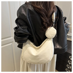 Detail of a beige crescent nylon crossbody bag with a round mini coin purse attachment