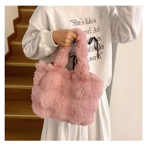 Close-up of pink faux fur tote bag with plush handles for soft autumn winter fashion