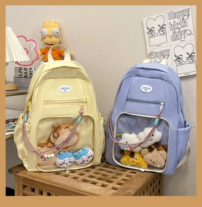 Dettaglio delle finestre trasparenti gialle e viola per peluche su zaini per studenti medi