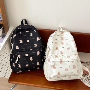 Detail of cute bear printed backpacks in black and beige with multi-pocket storage