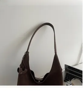 Detail view of the soft dark brown suede tote bag with durable slender handle strap