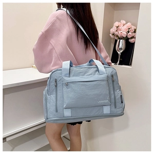 Close-up of a light blue waterproof fitness travel bag with multiple zipper pockets