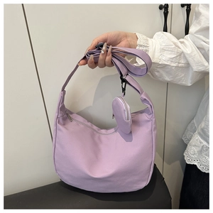 Detail view of a lavender nylon crescent bag with adjustable strap and small round coin purse