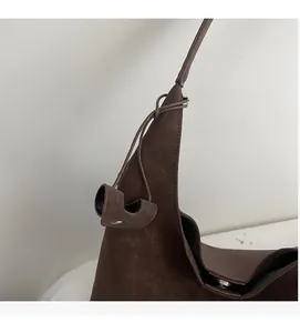 Detailed view of dark brown faux suede tote featuring metallic rivet accents and textures