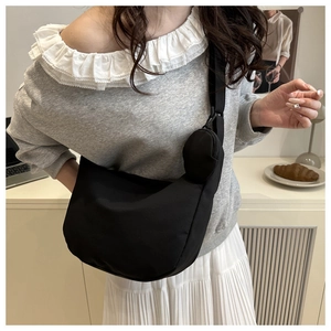 Black nylon crescent crossbody bag with detachable mini coin purse and wide shoulder strap