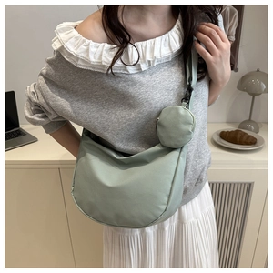 Close-up of mint green nylon crescent crossbody bag with matching detachable coin purse