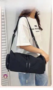 Macro detail of spacious black nylon crossbody travel bag with adjustable strap and zippers