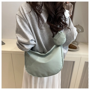 Detail of light green nylon crescent bag with mini coin purse on a lifestyle background