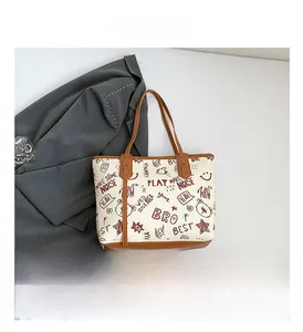 Gros plan du sac cabas beige avec imprimés d'ours vintage et anses en cuir marron contrasté