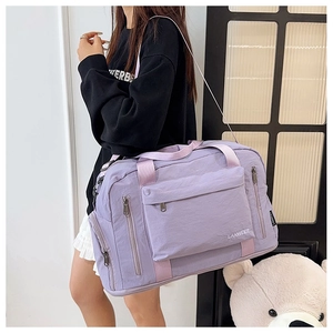 Close-up of a purple nylon travel bag with multiple zip pockets and reinforced handles