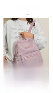 Detail view of pink water-resistant nylon backpack with smooth dual zippers and front pocket