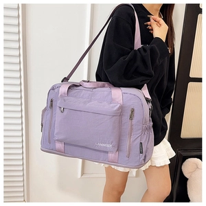Detail of a purple nylon travel bag featuring spacious pockets and durable shoulder straps