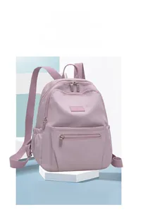 Close-up of a purple nylon backpack with multiple zippers on a geometric platform