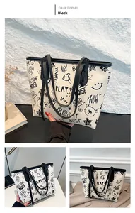 Détail du grand sac cabas blanc avec imprimés graffiti noirs et fines bandoulières