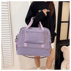 Detail view of purple travel bag with adjustable strap and separate bottom compartment