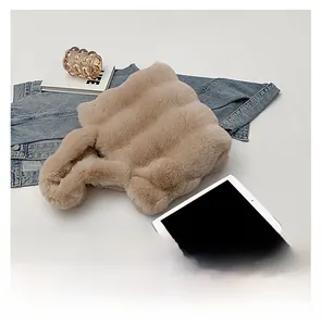 Détail d'un sac à main en peluche beige ondulé assorti d'une tablette et d'une veste