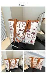 Détail du sac cabas contrasté avec imprimé gribouillis de dessins et finitions cuir