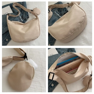Detail view of a beige nylon hobo bag featuring a small round coin purse and metal zipper