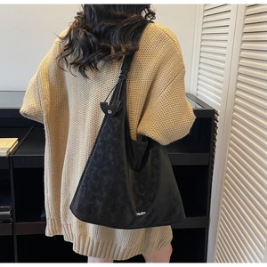 Detail of the black faux suede tote bag showing its large capacity and soft texture