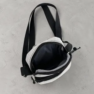 Detail view of small mesh crossbody bag with dual zipper opening and spacious interior