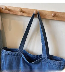 Détail des longues bandoulières et des coutures renforcées sur un sac fourre-tout en toile
