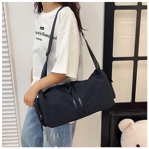 Detail view of the black nylon yoga travel bag with side zipper pocket and adjustable strap