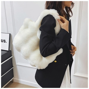 Gros plan détaillé sur la texture peluche blanche douce et la grande capacité de ce sac fourre-tout