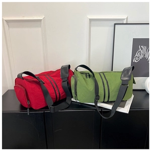 Detail view of red and green nylon yoga travel bags with side zipper and black straps