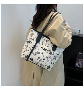 Détail d'un grand sac cabas blanc avec motifs griffonnés noirs et fines bandoulières