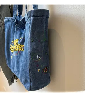 Détail du sac cabas en denim bleu avec broderies d'étoiles et lettrage Joyful Heart
