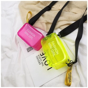 Detailed macro view of vibrant pink and neon yellow mini PVC jelly bags with fashion text