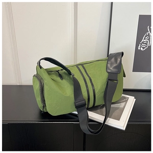 Close-up of olive green nylon yoga bag with black straps on a decorative white pedestal