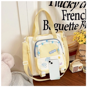 Detail of yellow and white patchwork tote bag with mesh pocket and happy days embroidery