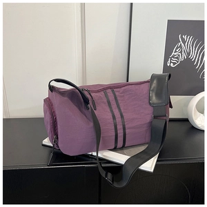 Detail view of purple cylinder travel bag with dual zippers and separate side compartment