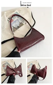 Detailed macro view of the wine red crocodile embossed pattern and glossy PU leather finish