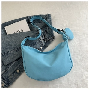 Detail of light blue nylon crescent bag with adjustable strap and small round coin purse