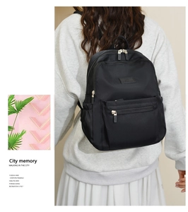Detailed view of lightweight black nylon backpack with durable zipper and brand logo patch