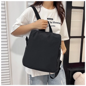 Close-up of a stylish black nylon backpack with side zipper detail and adjustable straps