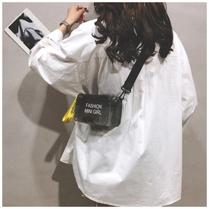 Detail of transparent black PVC saddle bag with wide strap worn by a model
