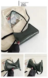 Detailed close-up showing dark green crocodile pattern leather and interior of the handbag