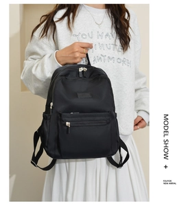 Detail of black nylon backpack with multi-compartment storage and smooth zipper pulls
