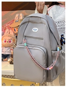 Zaino minimalista in nylon grigio con tasche multiple e ciondoli con perline colorate