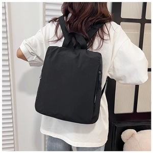 Detail of black nylon backpack with top handles and adjustable straps for daily use