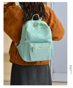Close-up of mint green nylon backpack with JINGPIN logo and durable metal zipper details