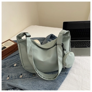 Detail of light green nylon crescent bag with adjustable strap and small round coin purse