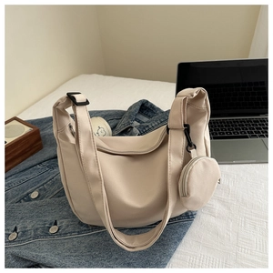 Detail of beige nylon crossbody bag with matching round coin purse and adjustable strap