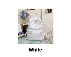 Close-up of white canvas backpack featuring blue heart patterns and woven zipper pulls