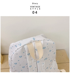 Close-up of heart and star print backpack top handles with vintage diary text style
